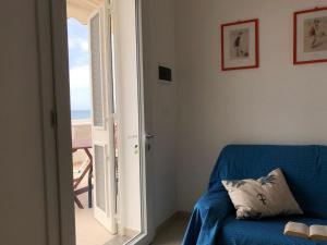 a blue couch in a room with a view of the ocean at Casa fronte mare a Torre Vado 2 in Torre Vado