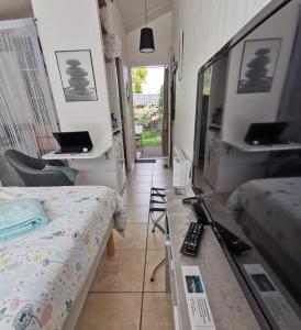 ein Schlafzimmer mit einem Bett und einem Schreibtisch mit einem Laptop in der Unterkunft Chambre Indépendante "Terre Rouge" in Martignas-sur-Jalle + 36 Fotos