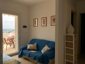 a blue couch in a living room with a view of the ocean at Casa fronte mare a Torre Vado 2 in Torre Vado +13 photos