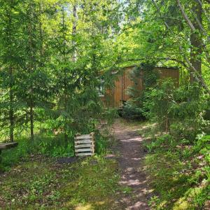 a dirt trail in a garden with a fence at Camping House Aivari in Inčukalns +15 photos
