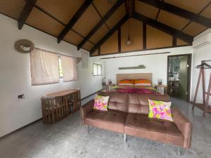a bedroom with a couch and a bed in it at Manta-Ray Beach Units in Arorangi