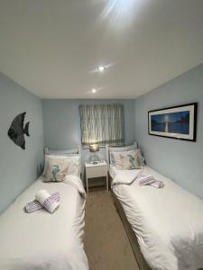 a bedroom with two beds and a table with a lamp at TWIN COVES at Curlew 1, The Cove, Brixham in Brixham