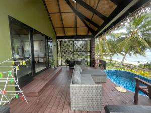 a living room with a couch and a swimming pool at Manta-Ray Beach Units in Arorangi