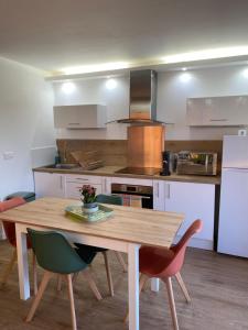 a kitchen with a wooden table and chairs at Front de Mer in Calais
