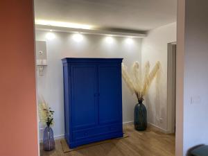 a blue cabinet in a room with two vases at Front de Mer in Calais