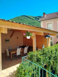 eine Terrasse mit einem Tisch und Stühlen sowie ein Haus in der Unterkunft Gîte La Rose des Alpes à Serres, 3 chambres, capacité 2 à 8 personnes, Cuisine, Terrasse, Parking et Garage in Serres + 19 Fotos