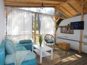 a living room with a blue couch and a tv at The magical place in Chernomorets