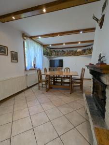 a dining room with a table and chairs and a fireplace at W Starym Sadzie in Białowieża +11 photos