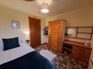 ein Schlafzimmer mit einem Bett und einer Holzkommode in der Unterkunft 18 Tarskavaig in Tarskavaig