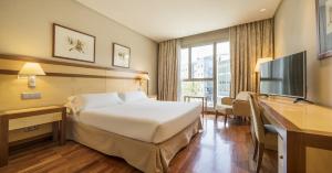 a hotel room with a bed and a flat screen tv at Ilunion Alcalá Norte in Madrid