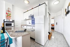 a kitchen with white cabinets and a white refrigerator at Holiday Dream near Yumbo in Playa del Ingles