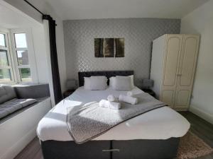 a bedroom with a large bed with towels on it at 2 bed flat sleeps 4 Swansea centre in Swansea