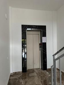 a hallway with a white door and a black wall at Sea You Soon Apartment in Shëngjin