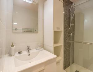 a white bathroom with a sink and a shower at Quartier des Théâtres - Hyper Centre - Zen Apparts in Troyes