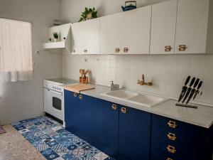 a kitchen with blue and white cabinets and a sink at Alojamiento Rural Casa la Abuela in Arbuniel