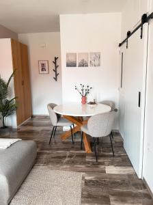 una sala da pranzo con tavolo e sedie bianchi di Lefkada City Escape a Città di Lefkada