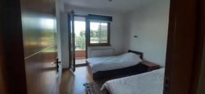 Cette chambre comprend 2 lits et une porte coulissante en verre. dans l'établissement شقة في اليجا appartment in Ilidza Sarajevo, à Sarajevo