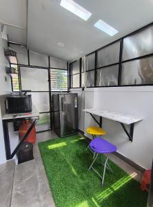 a room with a table and two chairs and a green rug at The Serene Retreat in Eramalloor