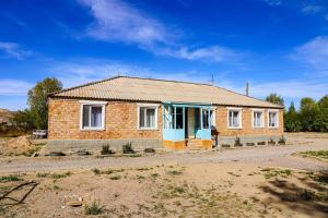 a small brick house with a blue door at By the road in Kara-Koo