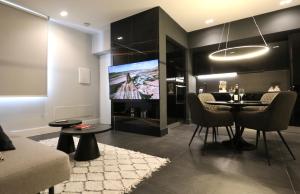 a living room with a dining table and a tv at Spacious Modern Fully equipped Apartment in Monumental Building - Parking - Historical Centre in Olbia
