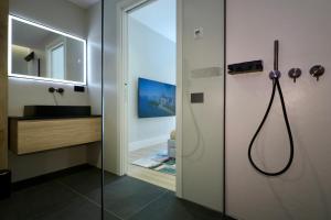 a bathroom with a shower with a sink and a mirror at Spacious Modern Fully equipped Apartment in Monumental Building - Parking - Historical Centre in Olbia +81 photos