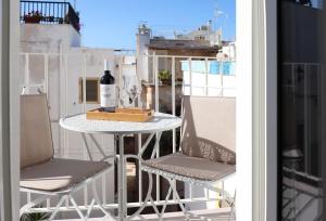 a table with a bottle of wine and two chairs on a balcony at La Piazzetta Luxury Rooms in Polignano a Mare