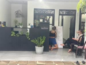 kobieta stojąca w pokoju z kobietą siedzącą w pokoju w obiekcie Hello Aliya Hostel w mieście Sigirija