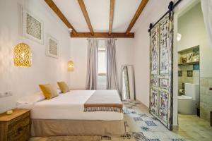 a bedroom with a bed and a bathroom at La Sultana de Vejer in Vejer de la Frontera
