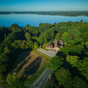 an aerial view of a house with a road and a lake at Klosterhof Aue W 14 in Bad Zwischenahn