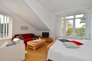 a bedroom with two beds and a red couch at Ferienwohnung Admiralssuite in Juliusruh