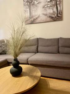 a living room with a table with a vase on it at Mabys home in Chalkida