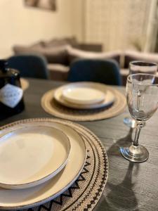 a table with plates and a wine glass on it at Mabys home in Chalkida