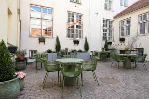 a patio with tables and chairs in front of a building at The Three Sisters Hotel in Tallinn