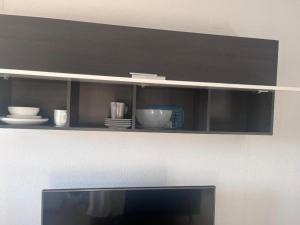 a shelf with bowls and dishes on it at 1-Bed Apt 10 mins to Beach Choose from 4 Pools in San Miguel de Salinas
