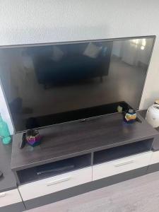 a flat screen tv sitting on top of a entertainment center at 1-Bed Apt 10 mins to Beach Choose from 4 Pools in San Miguel de Salinas