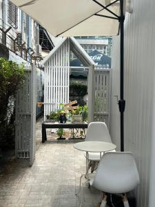 a patio with a table and two chairs and an umbrella at Cat in the box homestay in Godown +11 photos