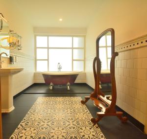 a bathroom with a tub and a large mirror at The Tredis Heritage by the Lake in Kodaikānāl