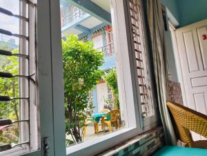una camera con finestra, tavolo e sedie di Hotel Unicorn a Pokhara Altre 7 foto