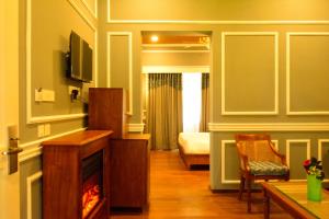 a room with a living room with a fireplace and a bed at The Tredis Heritage by the Lake in Kodaikānāl
