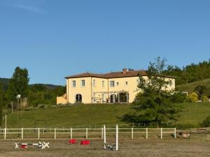 dom na szczycie wzgórza z płotem w obiekcie Agriturismo In Campagna w mieście Santa Fiora