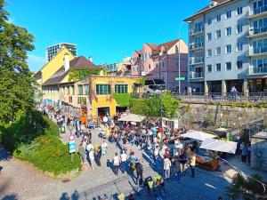 una multitud de personas caminando por una calle en una ciudad en Lidmansky 3 - Tinyhomes Klagenfurt, en Klagenfurt