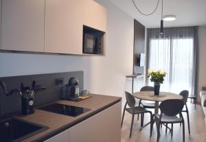 a kitchen with a table and chairs and a kitchen with a sink at Baia delle Rose Holiday Apartments in Costa Volpino