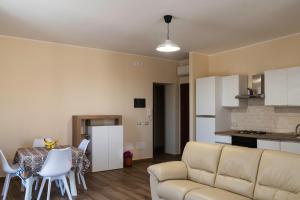 a living room with a couch and a table and chairs at Limpiados Housing in Licata