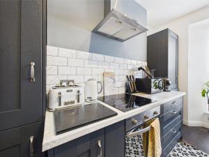 a kitchen with a sink and a stove at Elegant 1-Bed Apt | Central Falmouth | Parking & WiFi | Lockbox Entry | Walk to Town & Pubs | Quiet Residential Road | Top Floor Apartment | Near Train Stations & Beaches in Falmouth +28 photos