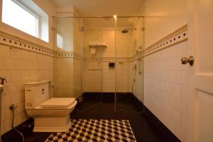 a bathroom with a toilet and a glass shower at The Tredis Heritage by the Lake in Kodaikānāl