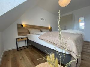 a bedroom with a large bed with a wooden headboard at MeerZeit 20 in Carolinensiel