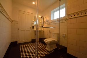 a bathroom with a toilet and a glass shower at The Tredis Heritage by the Lake in Kodaikānāl