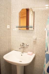 Un baño con un lavabo blanco y un espejo. en Apartment In City Center, en Tiflis