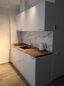Una cocina blanca con fregadero y encimera. en Seaview Panoramic Apartments ORBI Sea Towers Batumi, en Batumi