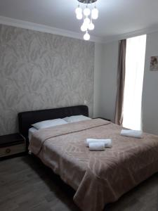 Un dormitorio con una cama con dos toallas encima. en Seaview Panoramic Apartments ORBI Sea Towers Batumi, en Batumi